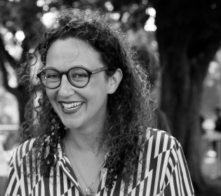 black-and-white photo of a woman with glasses in striped shir...