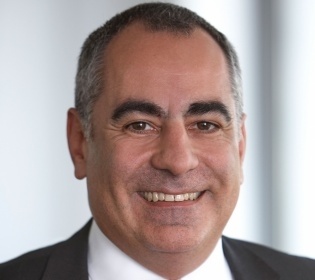 Man in suit with red white striped tie smiles into camera...