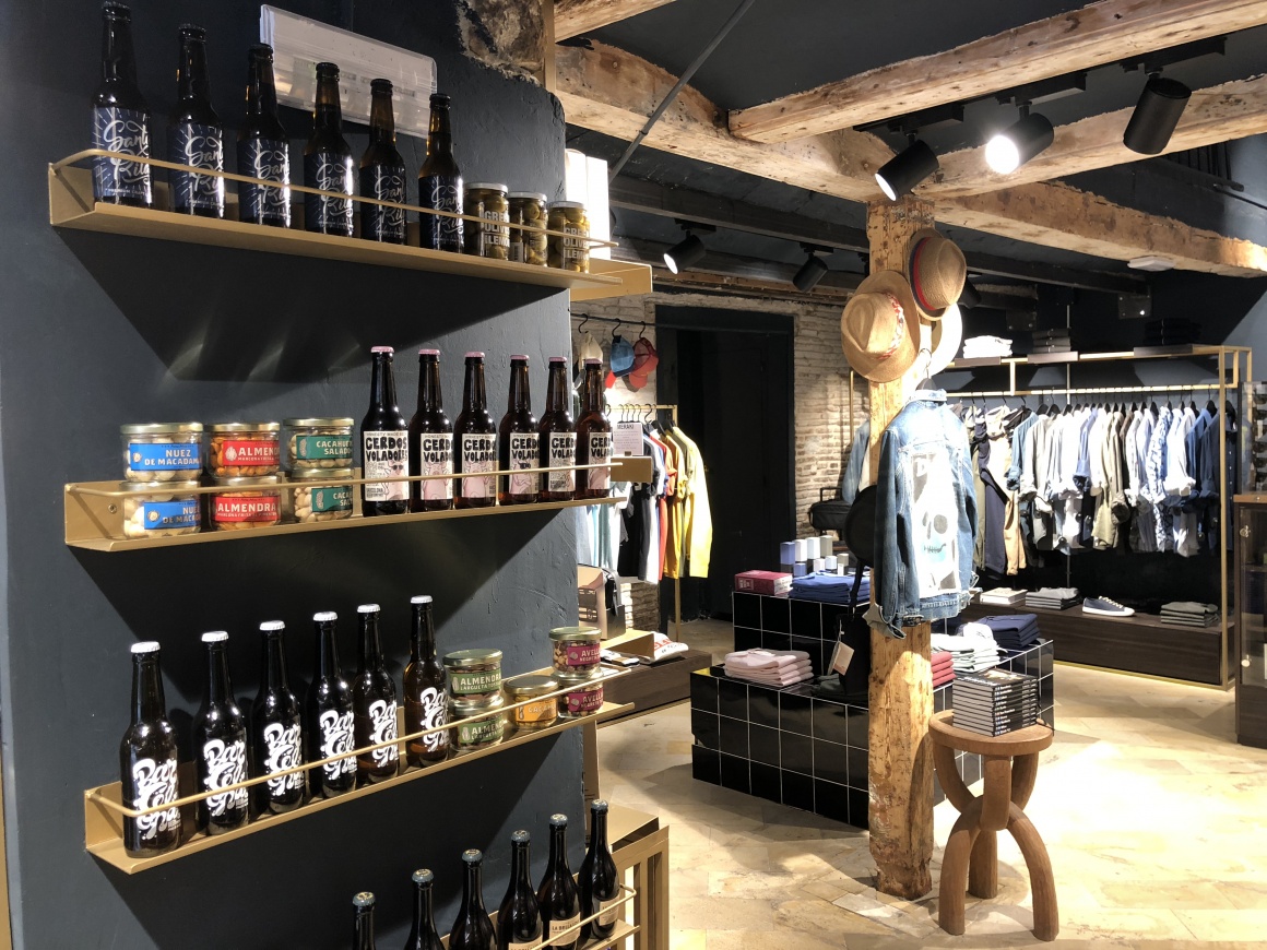 Craft beer and other groceries on a shelf.