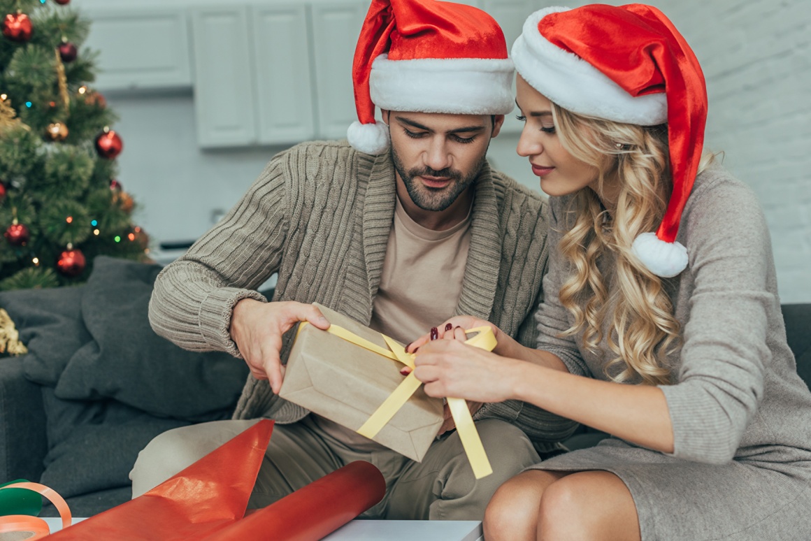 Young couple opens Christmas present
