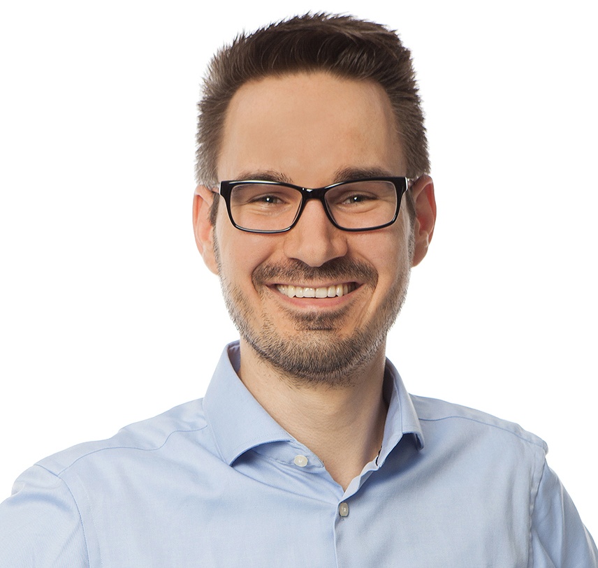 Man with glasses and dark hair smiles into the camera...