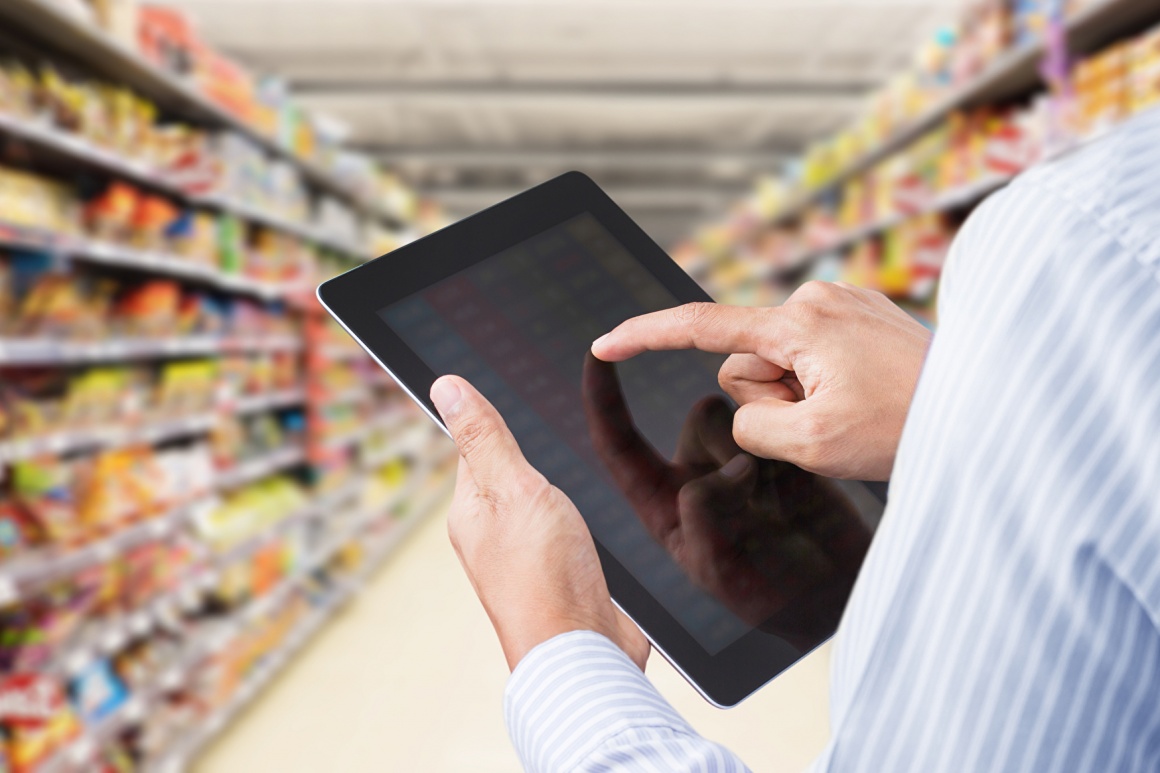 A man checking a tablet computer in a supermarket