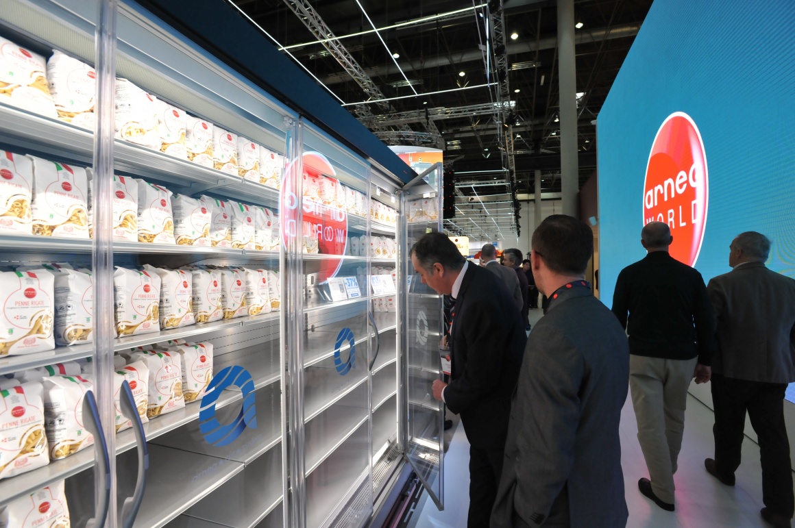 People in front of a refrigerated shelf