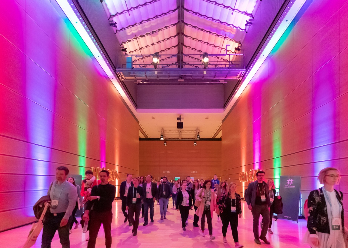 People walking through a colorfully lit corridor