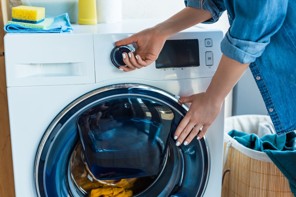 Person starting a washing machine.