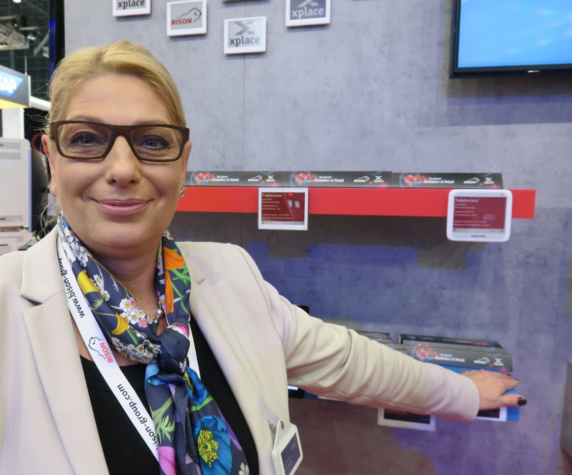 A woman at an exhibition stand with small electronic price tags...