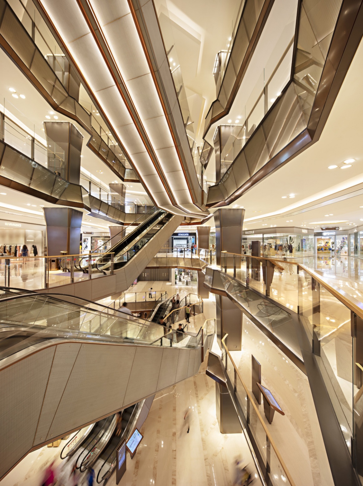 The interior of a shopping center with modern design and escalators...