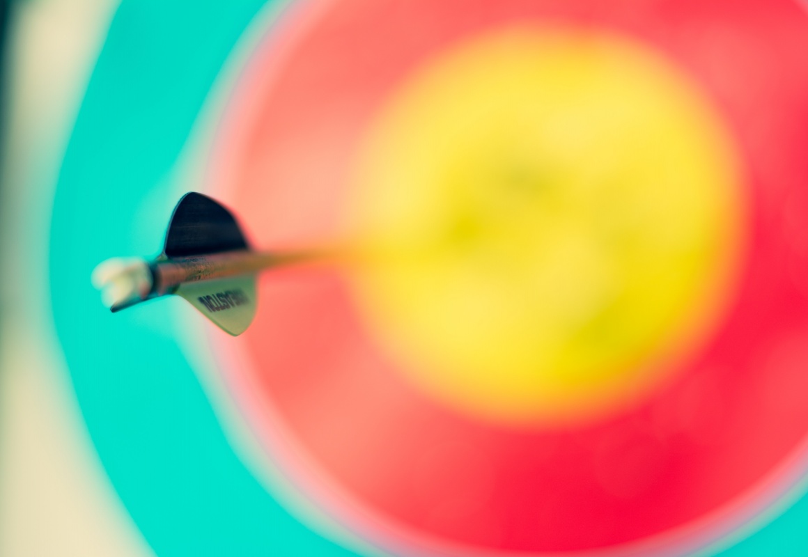A dart is stuck in a blurred target