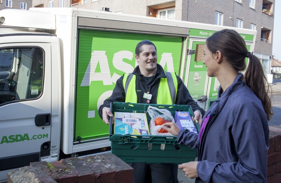 A delivery man is carrying a big basket talking to a customer...