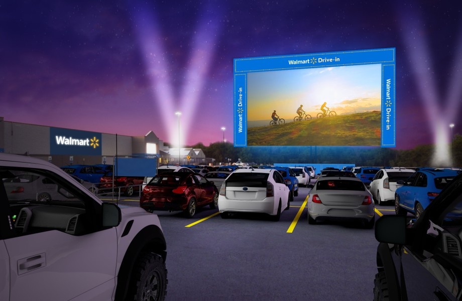 A screen and cars in a drive-in movie theater