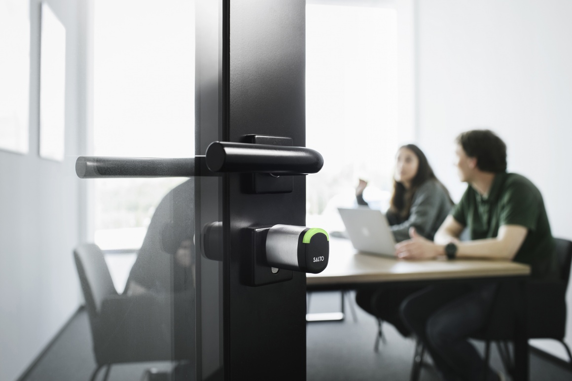 An open glass door at a meeting room with an electronic cylinder lock...