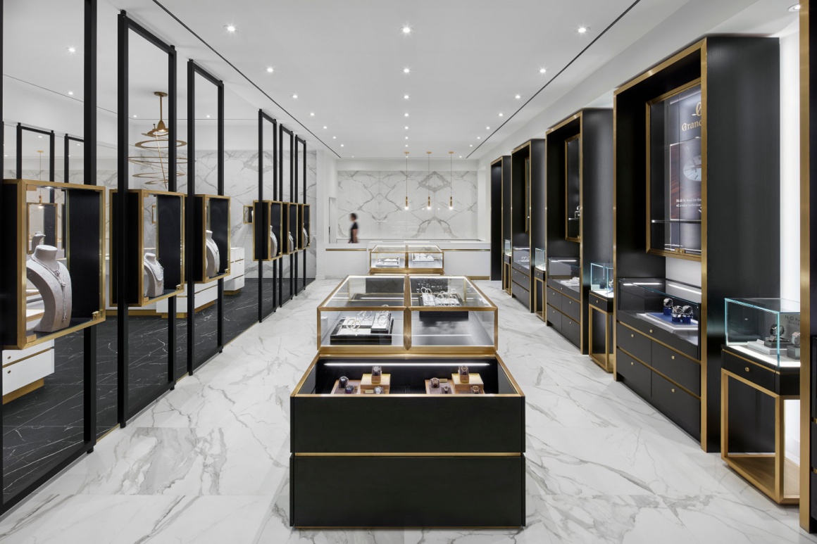 A jewelry store with white walls, golden decoration and black showcases...