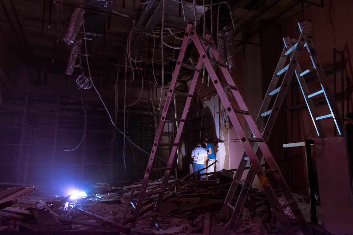 renovations in a dark room with ladders, cables and one light source...