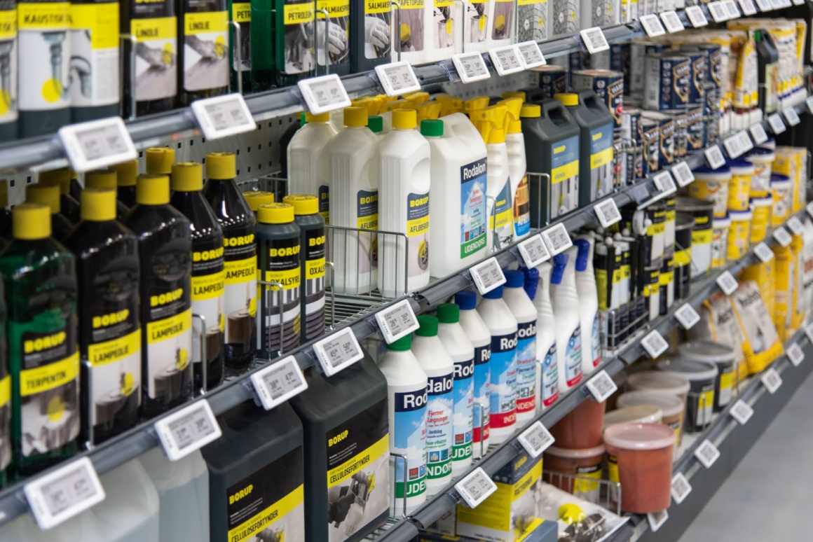 A shelf in a hardware store with products in bottles and electronic price tags...