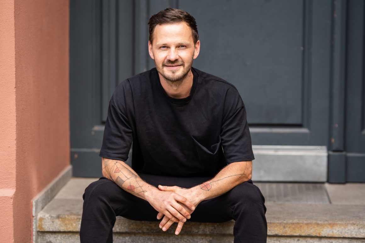 man in sitting position looks at the camera