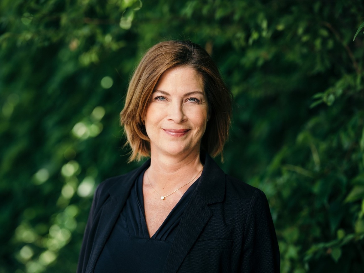 A woman in black clothes in front of a tree