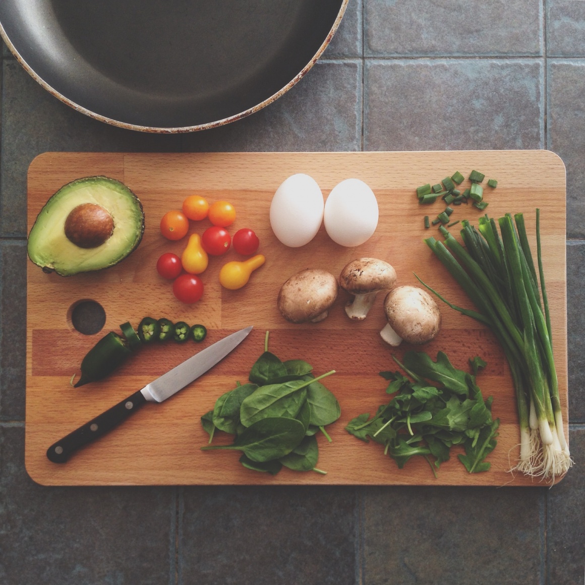 fresh vegetables and a knife on a wooden plate