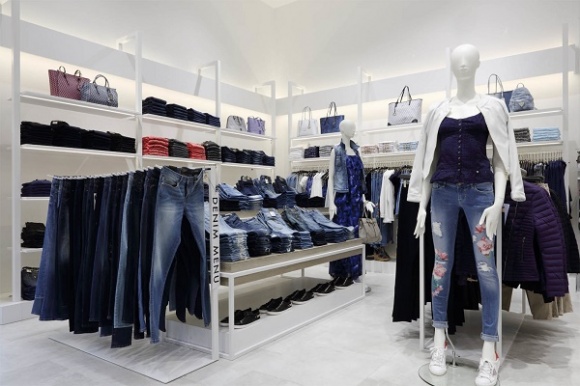 White shelving fixtures along the walls host the brands fashion-forward...