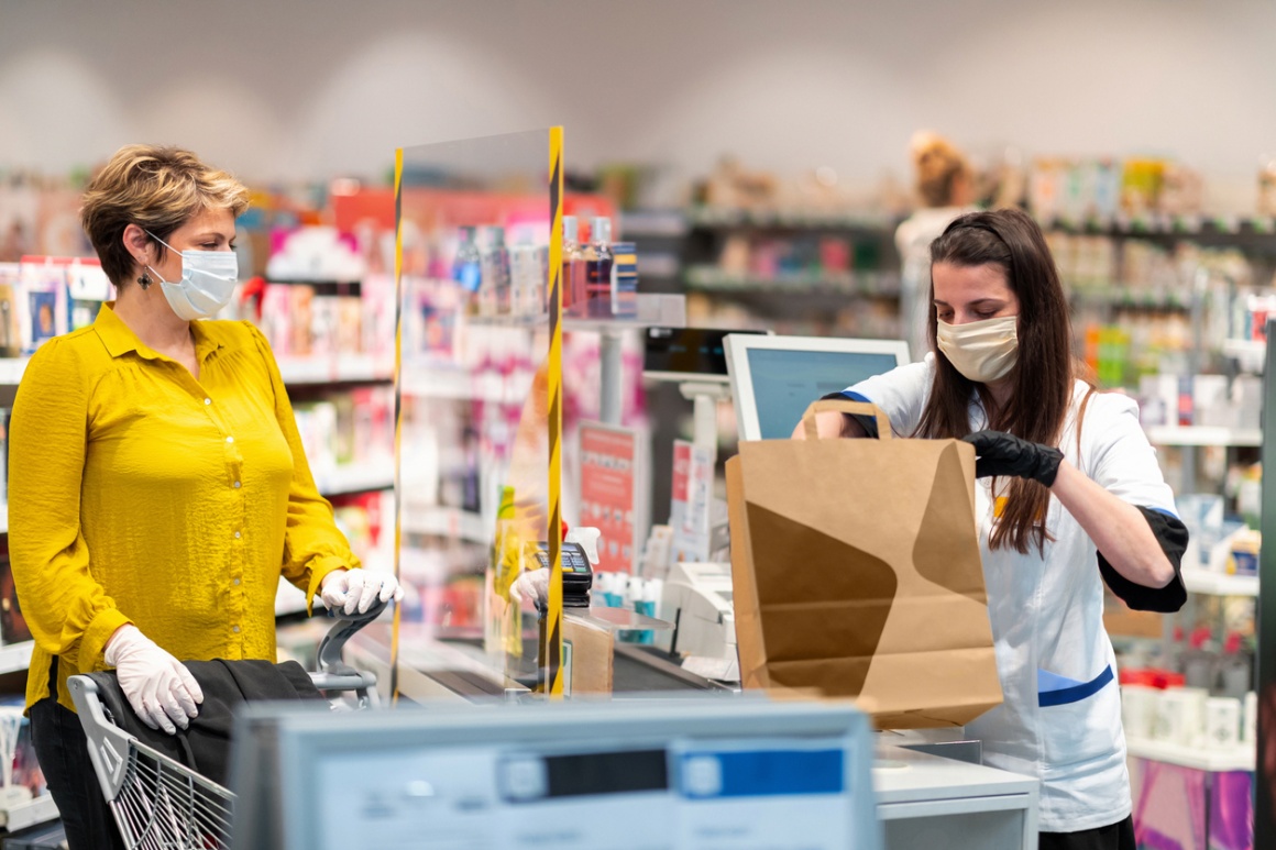 In a supermarket, a customer waits at the checkout line for the checkout to...