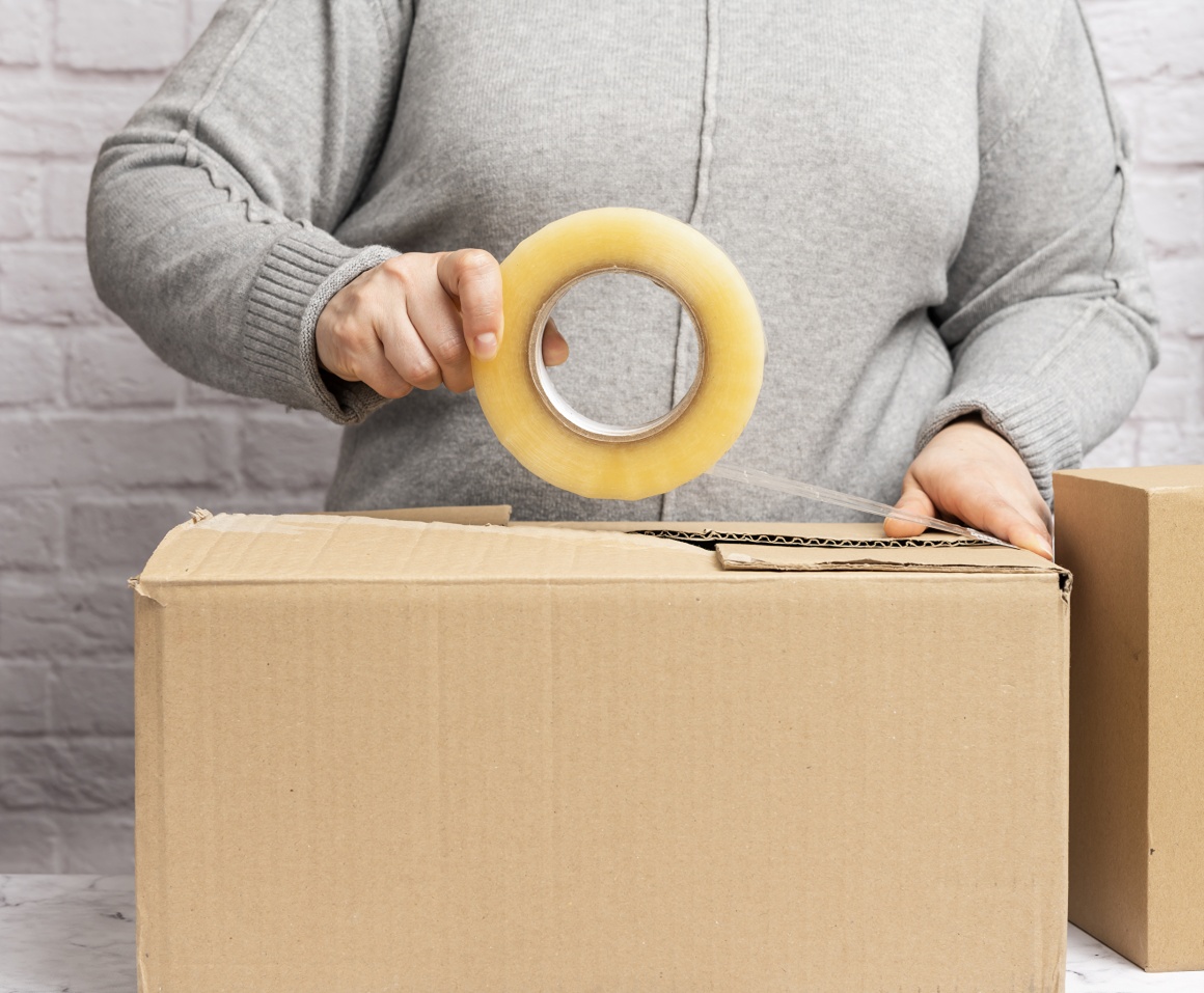 a woman wraps a package with tape